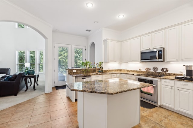 kitchen with white cabinetry, sink, stainless steel appliances, and dark stone counters