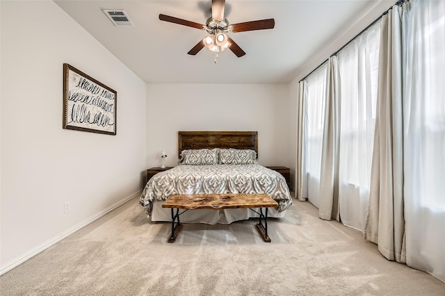 carpeted bedroom featuring multiple windows and ceiling fan