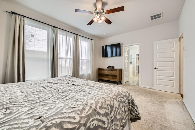 carpeted bedroom featuring ensuite bath and ceiling fan