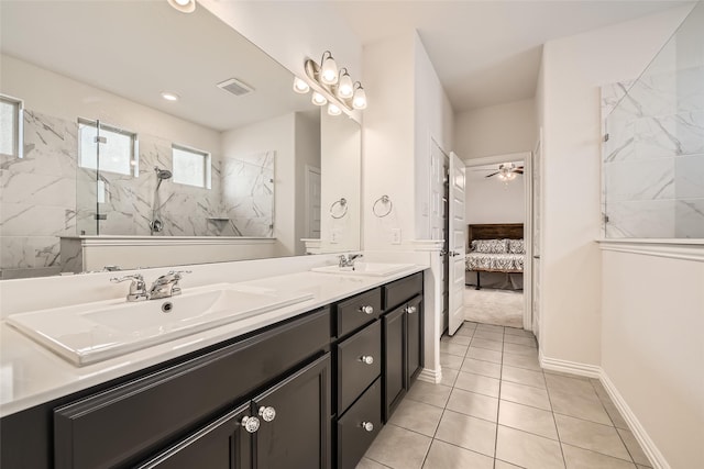 bathroom with a tile shower, ceiling fan, tile patterned flooring, and vanity