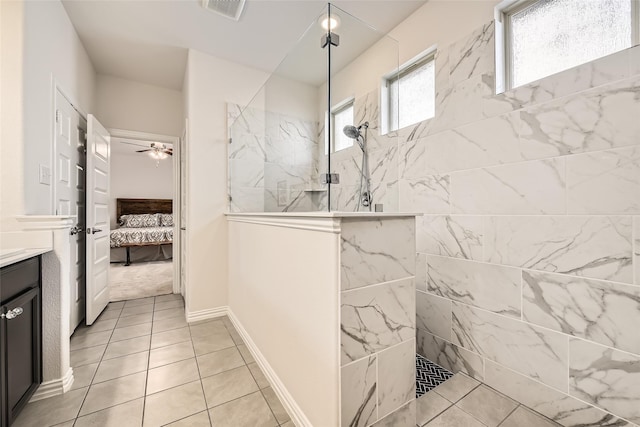 bathroom featuring tile patterned flooring, vanity, ceiling fan, and tiled shower