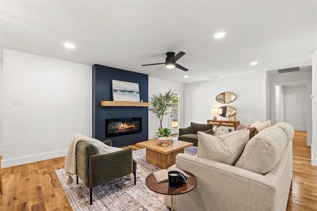 living room featuring ceiling fan and light hardwood / wood-style floors