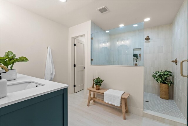 bathroom with vanity and a tile shower