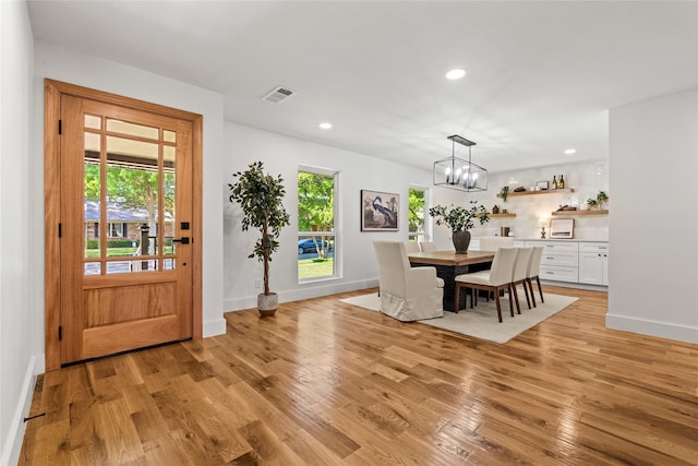 dining area with a chandelier and light hardwood / wood-style floors