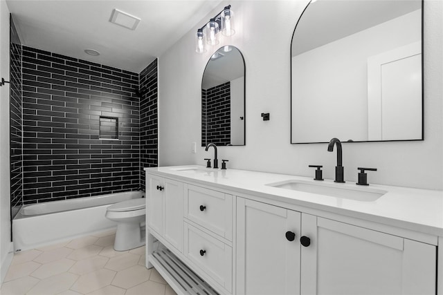 full bathroom with tiled shower / bath combo, vanity, tile patterned flooring, and toilet