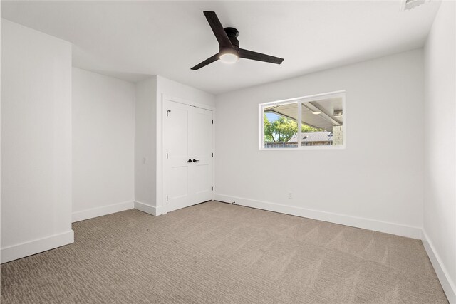 unfurnished bedroom with ceiling fan, a closet, and light colored carpet