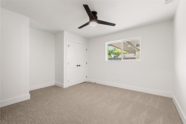 unfurnished bedroom featuring light carpet, ceiling fan, and a closet