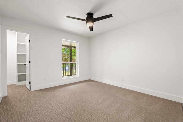 carpeted spare room featuring ceiling fan