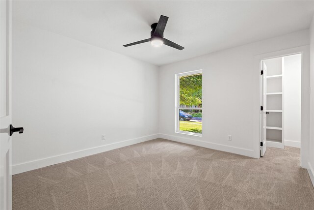 carpeted empty room featuring ceiling fan