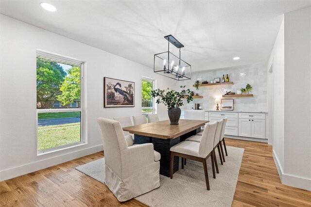 dining space featuring light hardwood / wood-style floors, plenty of natural light, and a notable chandelier