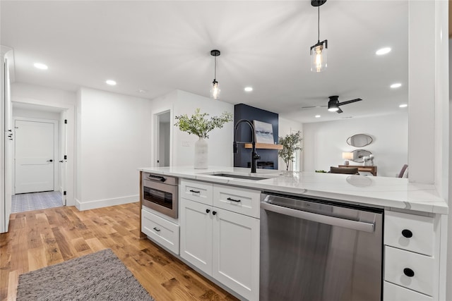 kitchen with light stone counters, ceiling fan, decorative light fixtures, dishwasher, and white cabinetry