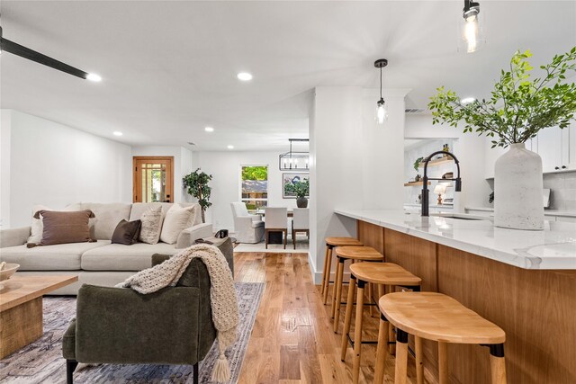 living room with a chandelier, light hardwood / wood-style flooring, and sink