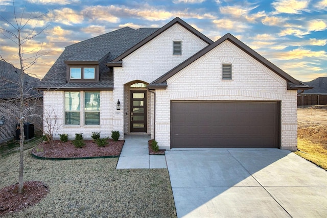 french country style house with a garage and central air condition unit