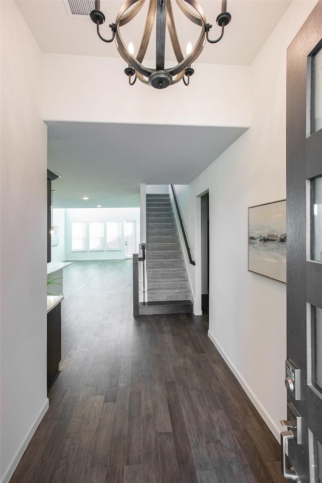 hall with dark hardwood / wood-style flooring and a chandelier