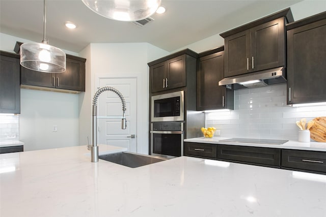 kitchen featuring stainless steel oven, black electric stovetop, sink, built in microwave, and decorative light fixtures