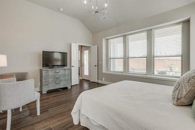 bedroom with lofted ceiling, dark hardwood / wood-style floors, and a notable chandelier