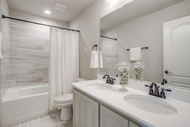 full bathroom with vanity, shower / tub combo, and toilet