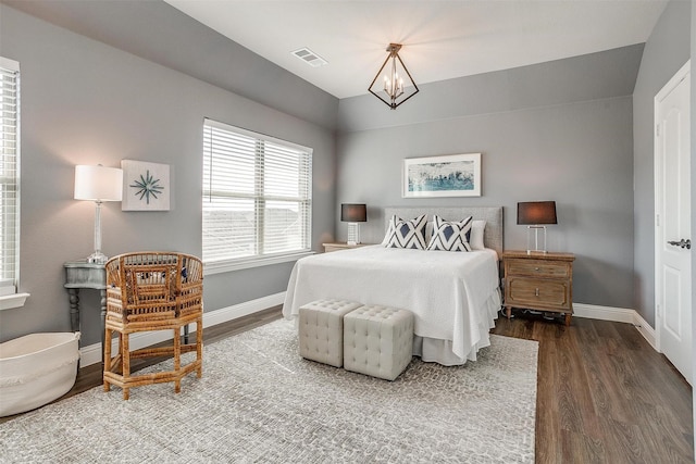 bedroom featuring dark hardwood / wood-style flooring and a chandelier