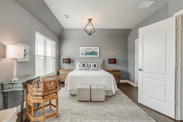 bedroom with vaulted ceiling, an inviting chandelier, and dark hardwood / wood-style flooring