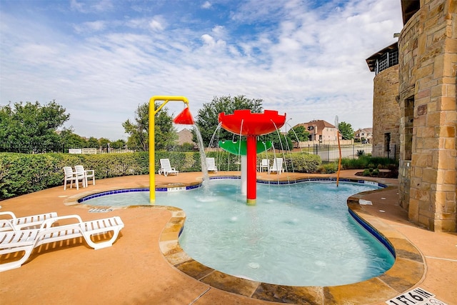 view of pool with pool water feature and a patio