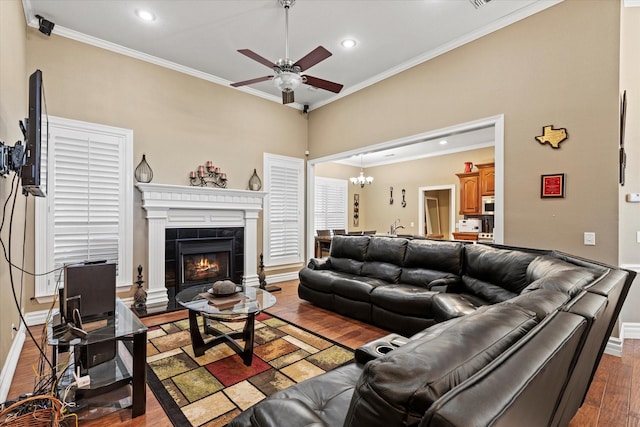 living room featuring a tile fireplace, crown molding, and wood-type flooring