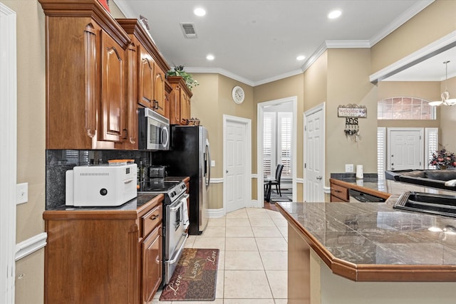 kitchen featuring kitchen peninsula, appliances with stainless steel finishes, ornamental molding, a notable chandelier, and light tile patterned flooring