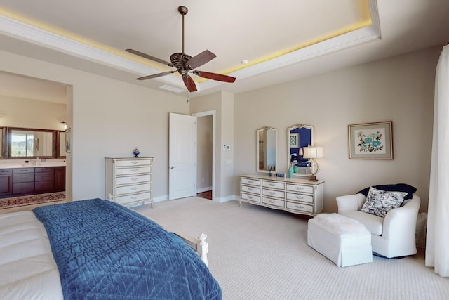 carpeted bedroom with connected bathroom, a tray ceiling, and ceiling fan