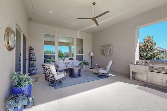 view of patio / terrace with grilling area, ceiling fan, exterior kitchen, and an outdoor fire pit