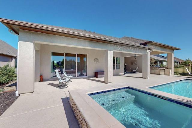 back of property with a patio area and a fenced in pool