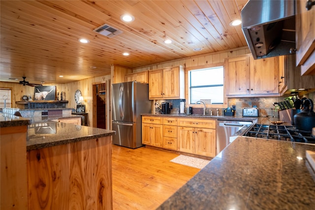 kitchen featuring range hood, light wood finished floors, visible vents, appliances with stainless steel finishes, and a sink