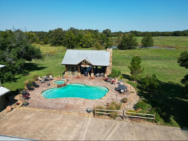 view of pool with a patio, a rural view, an in ground hot tub, and a lawn