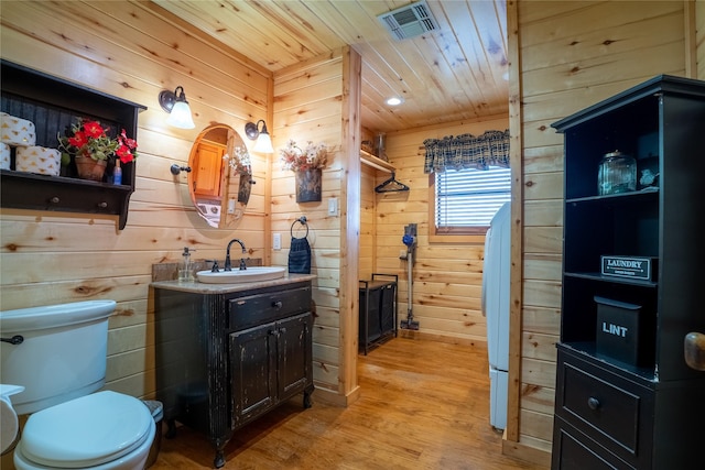 bathroom with toilet, wood finished floors, visible vents, vanity, and wood ceiling