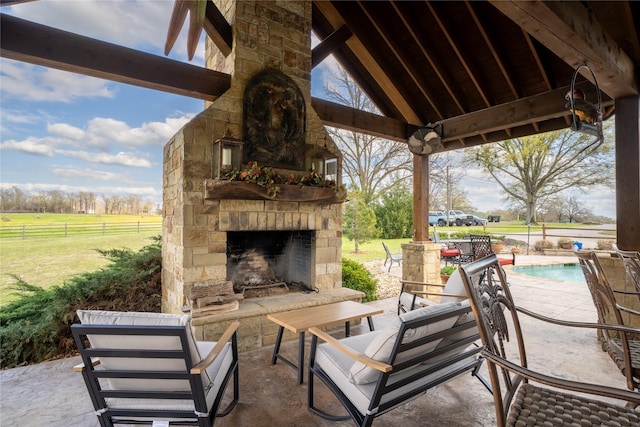 view of patio / terrace with a gazebo, an outdoor stone fireplace, fence, and an outdoor pool