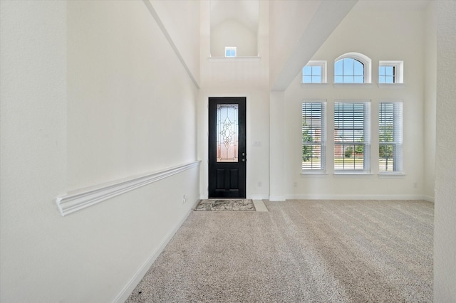 entryway featuring light colored carpet and a high ceiling