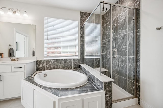 bathroom with separate shower and tub, plenty of natural light, and vanity