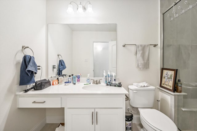 bathroom featuring a shower with door, vanity, and toilet