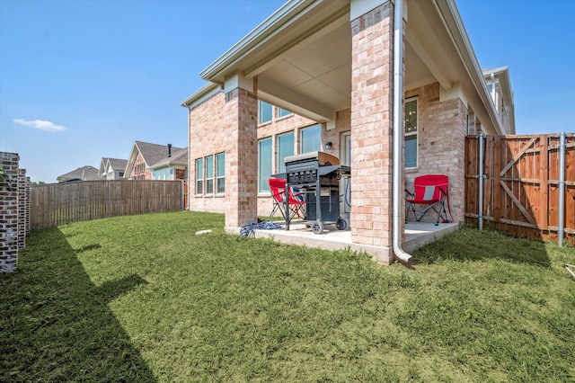 back of property with a yard and a patio