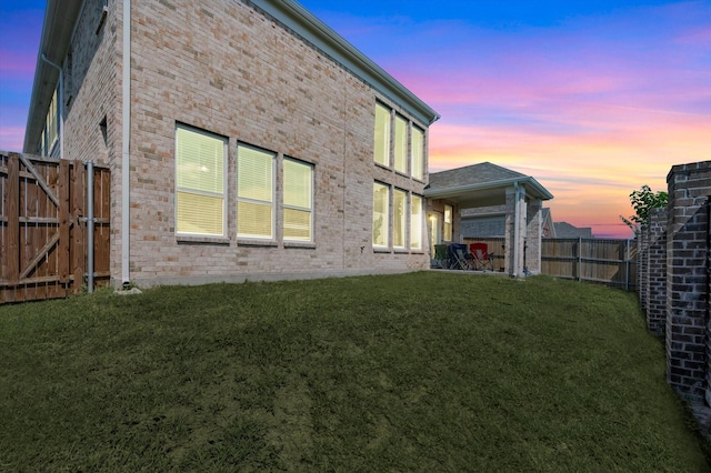 property exterior at dusk with a yard