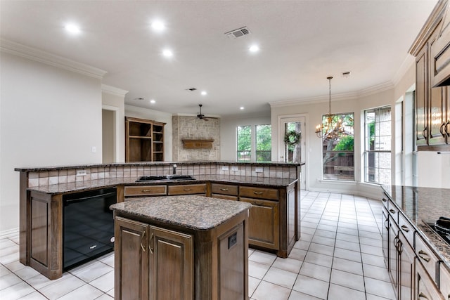 kitchen with pendant lighting, light tile patterned floors, black dishwasher, tasteful backsplash, and a kitchen island