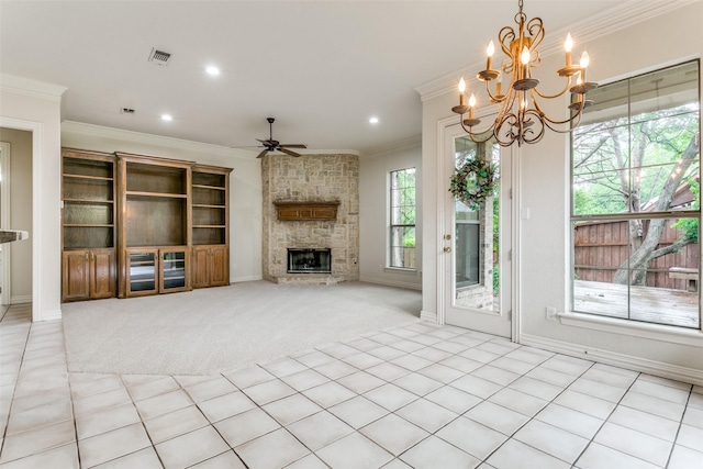 unfurnished living room with light carpet, a stone fireplace, ceiling fan with notable chandelier, and ornamental molding