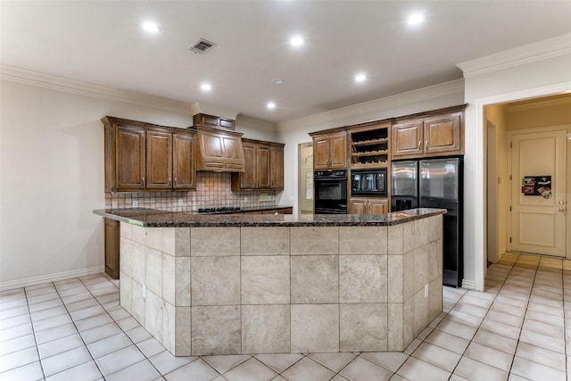 kitchen with dark stone counters, a kitchen island, and black appliances