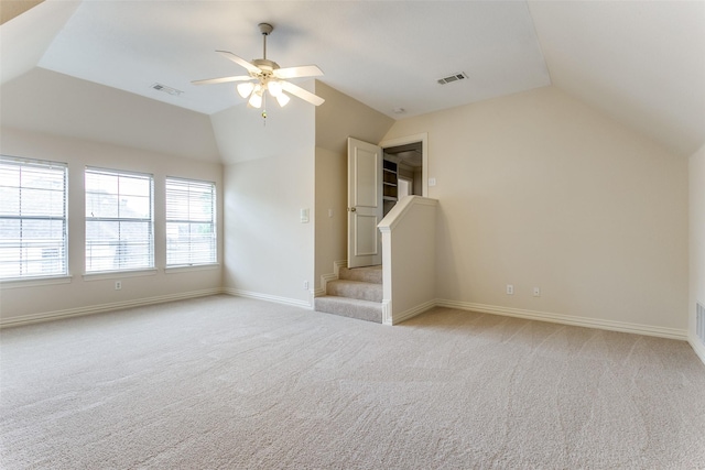 interior space featuring vaulted ceiling, light colored carpet, and ceiling fan