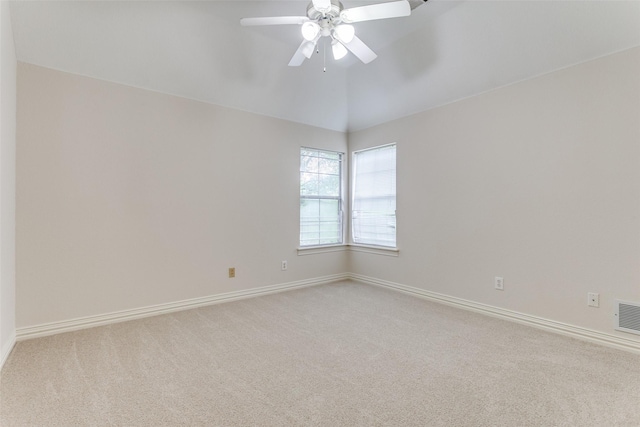 carpeted spare room featuring vaulted ceiling and ceiling fan