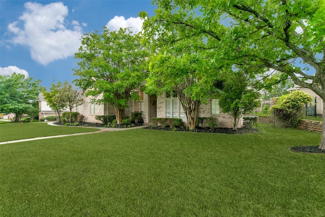 view of property hidden behind natural elements with a front lawn