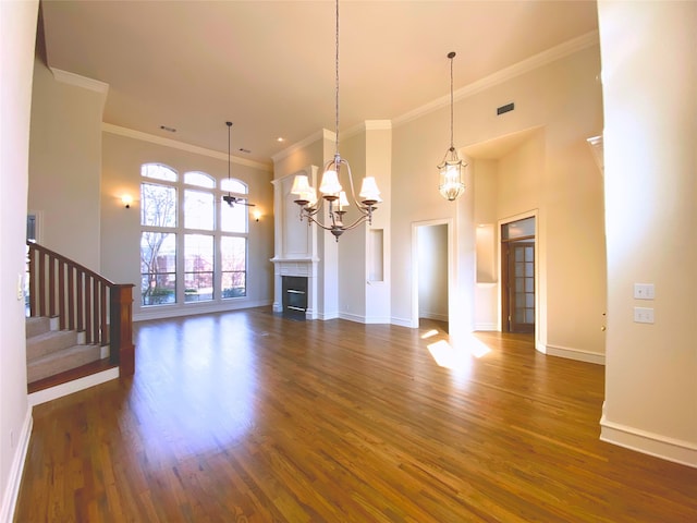 unfurnished living room featuring ornamental molding, dark hardwood / wood-style flooring, and a high ceiling