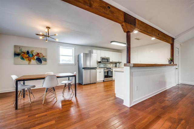 kitchen featuring sink, backsplash, white cabinets, light hardwood / wood-style floors, and stainless steel appliances