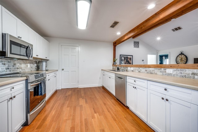 kitchen with backsplash, light wood-type flooring, white cabinets, and appliances with stainless steel finishes