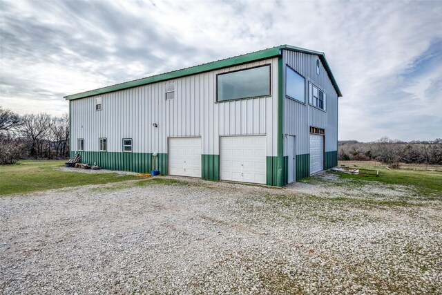 view of side of home featuring cooling unit, a garage, and a yard