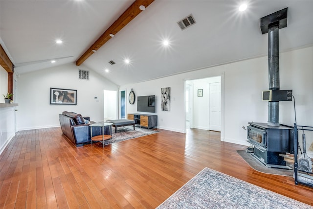 living room featuring lofted ceiling with beams and light hardwood / wood-style floors