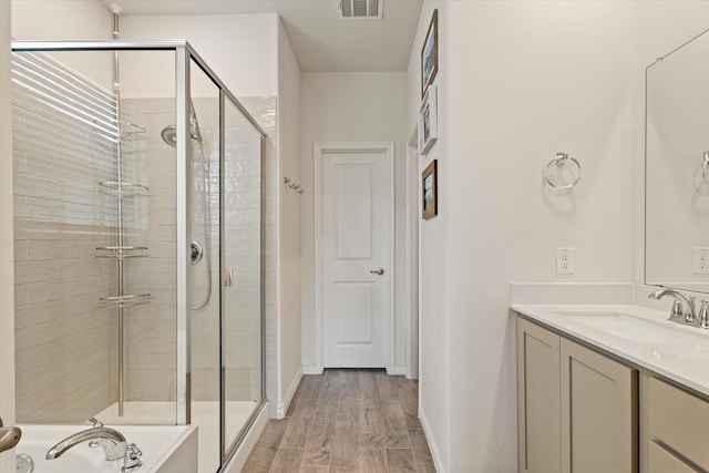 bathroom with vanity, wood-type flooring, and shower with separate bathtub